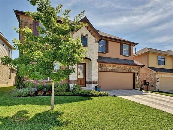 Lush landscaping adorns the entrance of this home at 11013 Desert Willow Loop