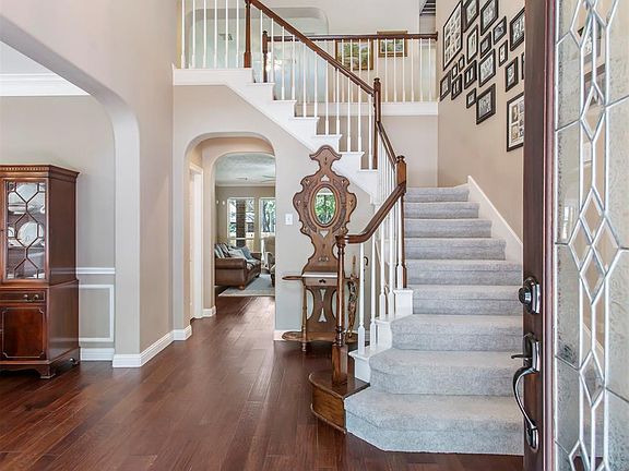 As you enter the home, you are greeted by a wrap around staircase and a large entry way. The beautiful wood floors are throughout most of the downstairs.