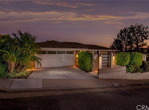 Professionally landscaped with custom privacy gate and exterior lighting.