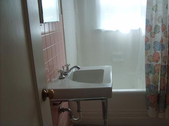 cozey little bathroom with tub and shower