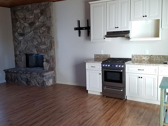 Living room with fireplace and kitchenette on first floor.