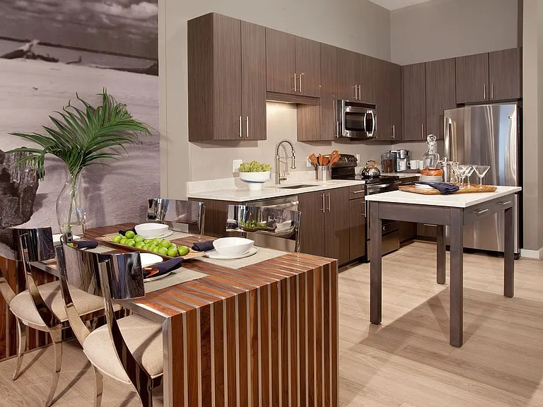 Dining area and open concept kitchen with quartz stone countertops, stainless-steel appliances, kitchen island and hard surface flooring