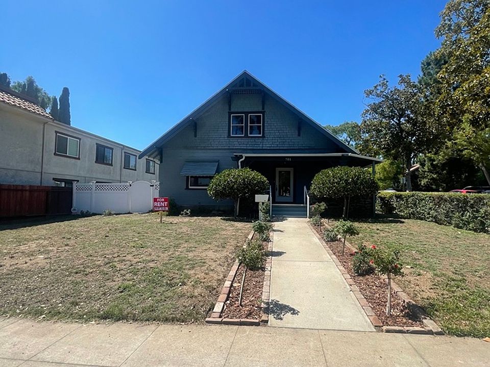 Front of house with large front lawn and blooming roses.
