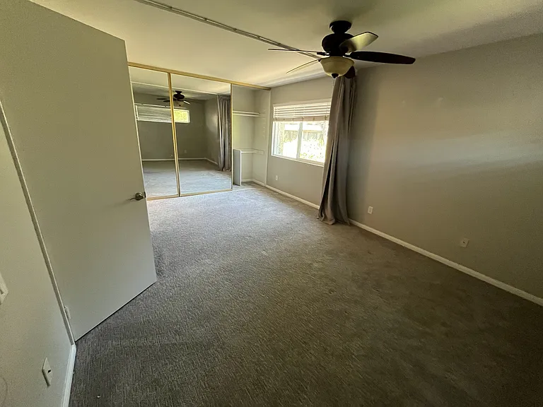 Master bedroom with large 3 mirror panel closet, remote control ceiling fan, and curtain divider which can be removed.