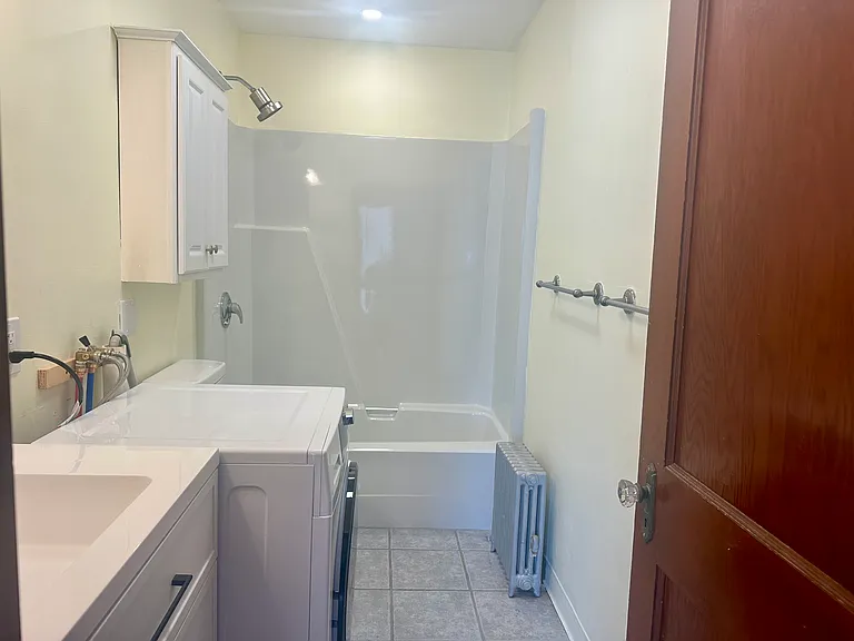 Bathroom with tub and high efficiency steam washer/dryer combo unit (hoses will be boxed in for aesthetics)