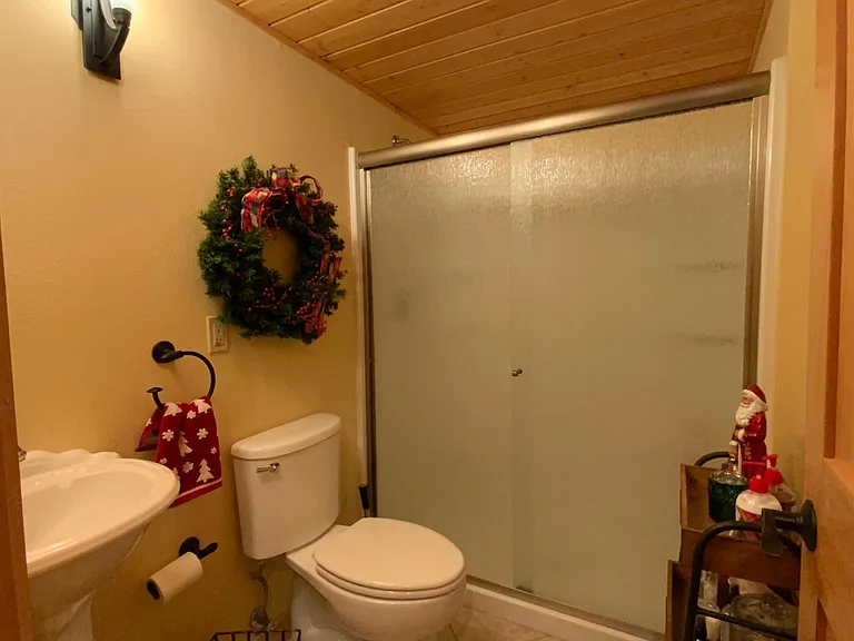 Main floor bath with corner pedestal sink and mirror.