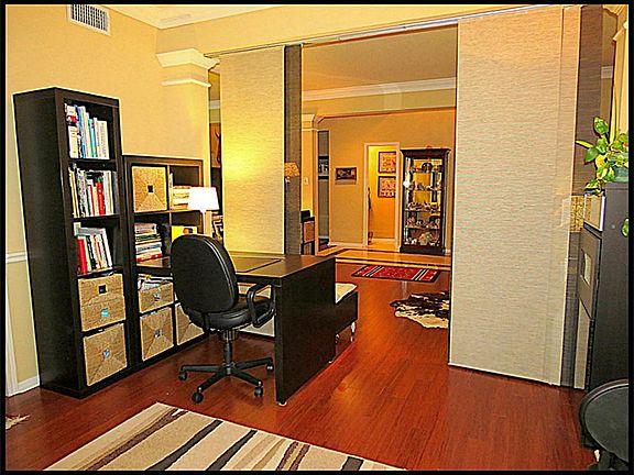 Formal dining room with bamboo hardwood floors, currently being used as a study.