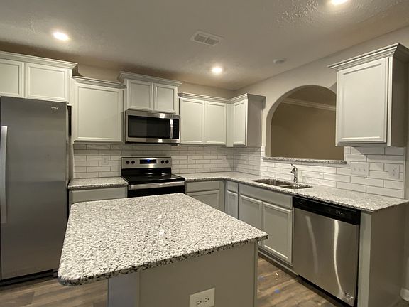 Kitchen with upgrade cabinets, granite, kitchen island, stainless steel appliances including refrig