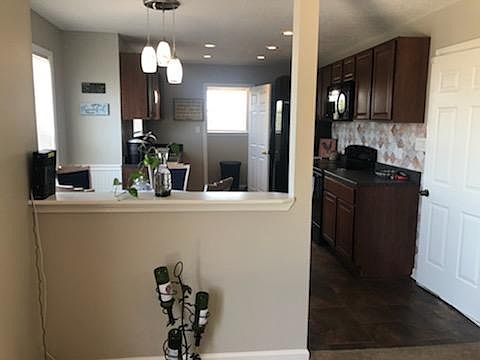 Open concept full kitchen with adjoining laundry room and side door to the garage.