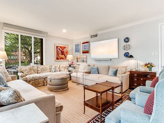 Living area featuring light-colored walls, crown molding, and recessed lighting