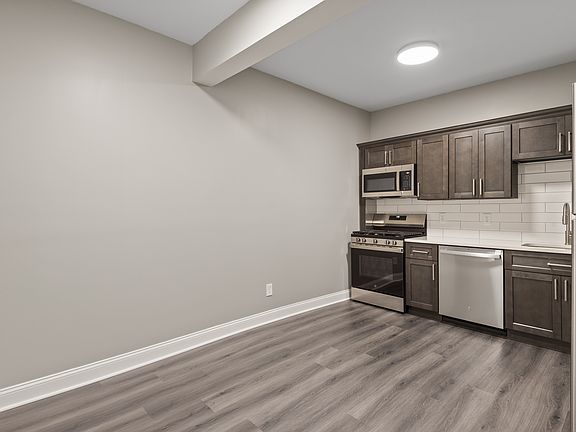 Kitchen with dishwasher, new cabinets, new appliances and quartz countertops.