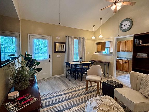 Living area with very tall ceilings, great lighting, smart TV, high-speed internet.
Dining area and kitchen in background