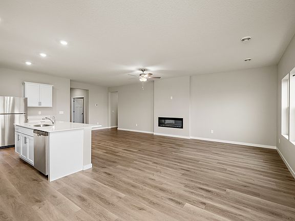 The family room is spacious with a ceiling fan and fireplace.