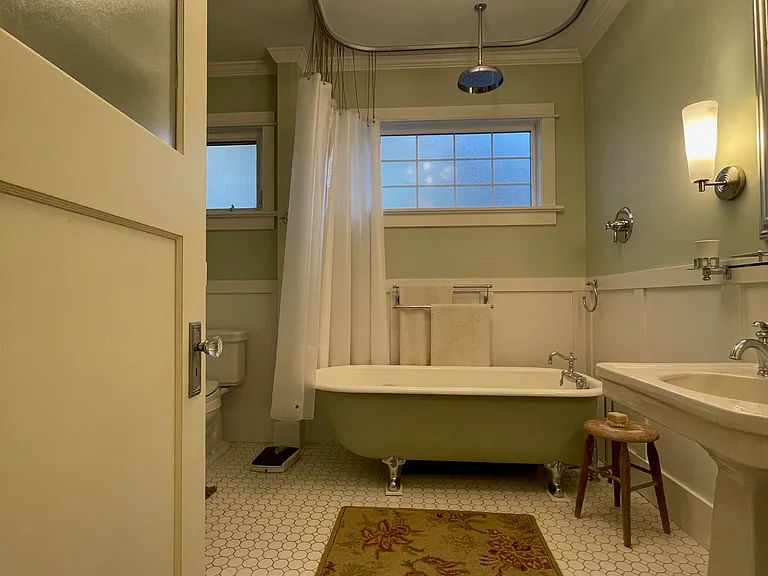 The coolest vintage bathroom with clawfoot tub and shower head, too.
