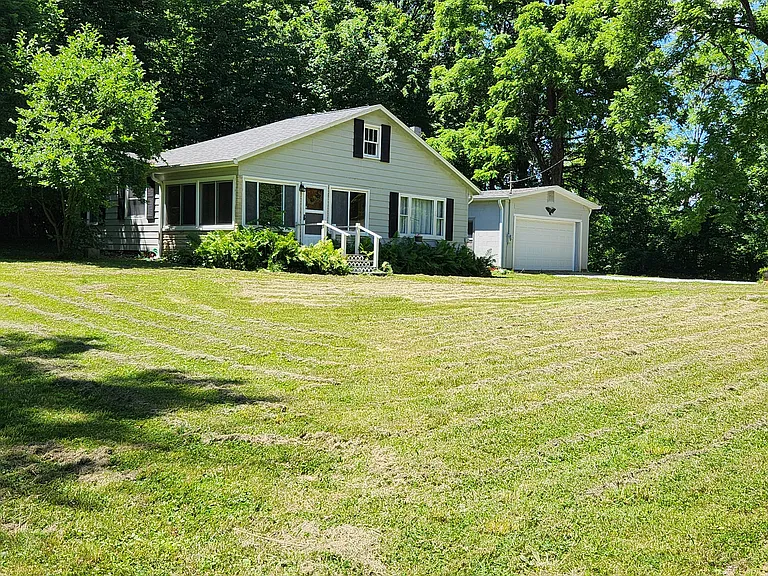 This home with large attached garage sets on the road on 5 acres.