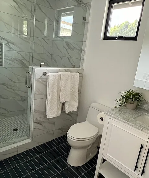 Upstairs full bathroom . Shower includes detachable hand shower and tiled bench.