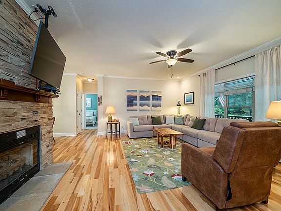 Open living room and dining area with seasonal gas fireplace.