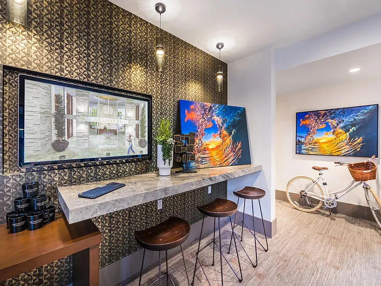 Work lounge with bar seating and vibrant artwork for casual productivity.