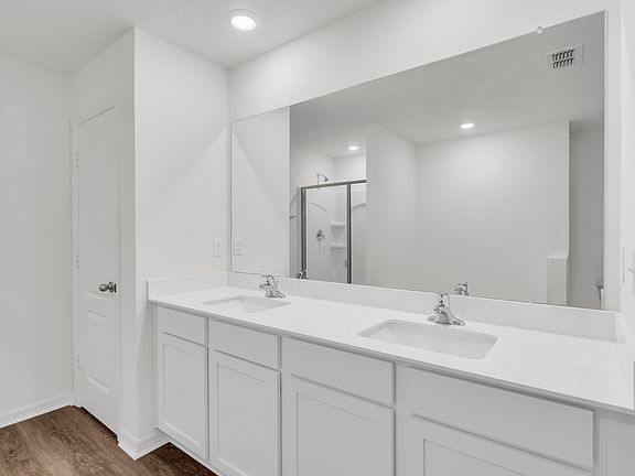 The master bathroom includes a dual sink, shower and bathtub
