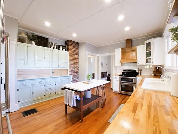 Huge kitchen with original refurbished Hoosier cabinets, exposed brick and wood floors.