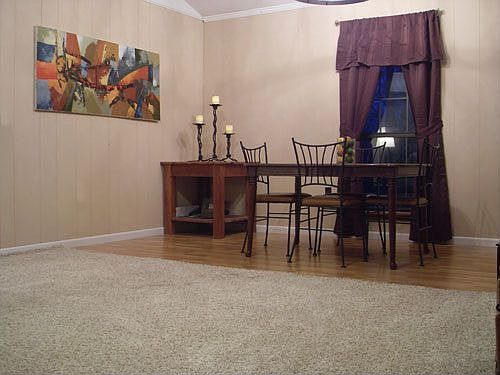 Dining area with laminate wood floors adjacent to living area