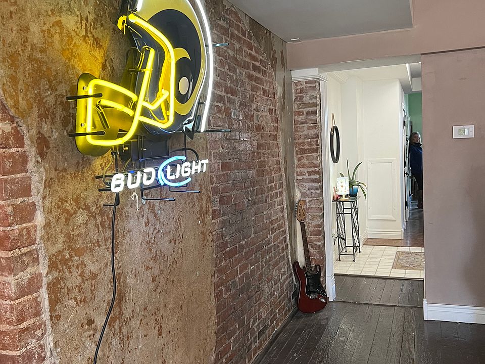 Dining / living area showing exposed brick looking toward entrance and kitchen.