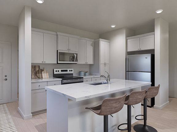 The kitchen has stainless steel appliances and plank flooring.