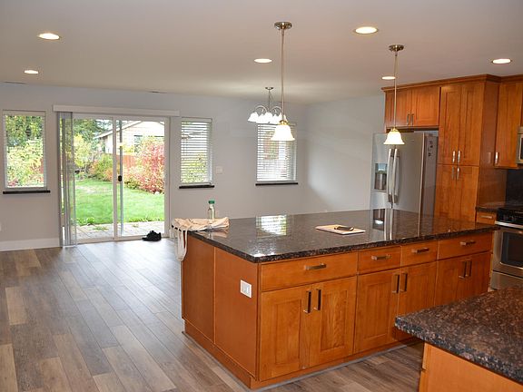 A North facing view through greatroom of covered patio and backyard, East fence and neighbor's shed.