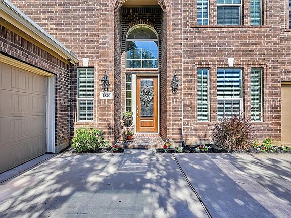 The solid wood door has leaded glass inserts with a dramatic window surround making the foyer light and airy.