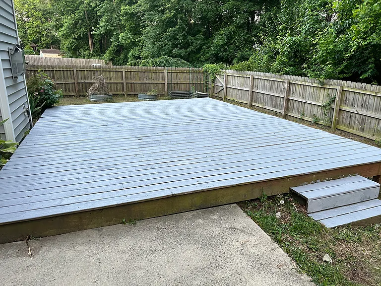 Fenced backyard with a large deck
