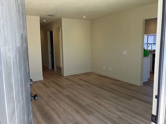 Entrance looking into living room with kitchen and dining area on the right. New LED recessed lighting in kitchen, living room, and hallway.