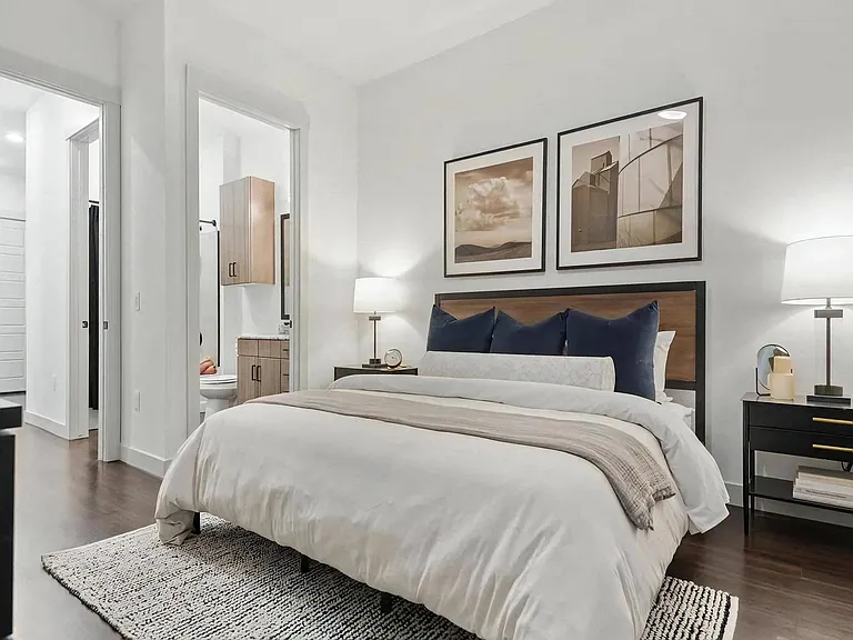 Apartment Bedroom with Open Bathroom View and Wood Flooring