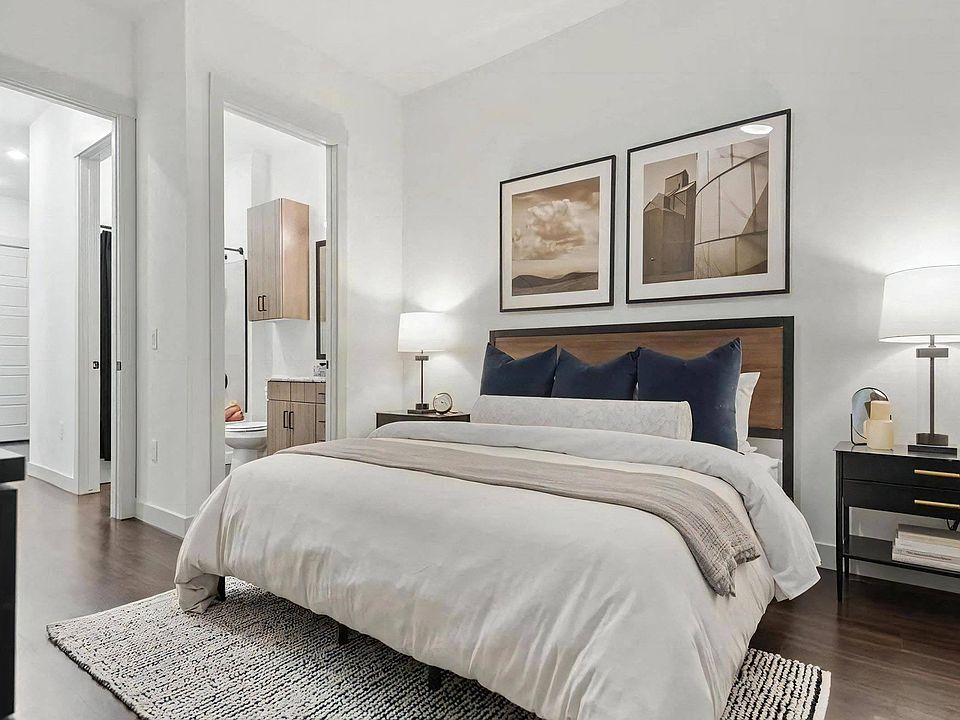 Apartment Bedroom with Open Bathroom View and Wood Flooring