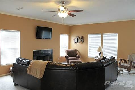 Living area of great room with ceiling fan.