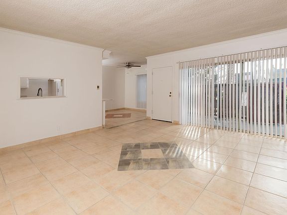 Living room, entry door, balcony/patio outside sliding doors, dining room (kitchen through the wall window