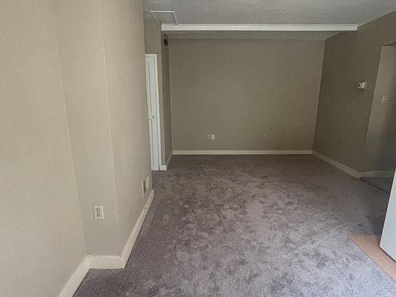 Large living room with brand new carpet and 2 large windows.