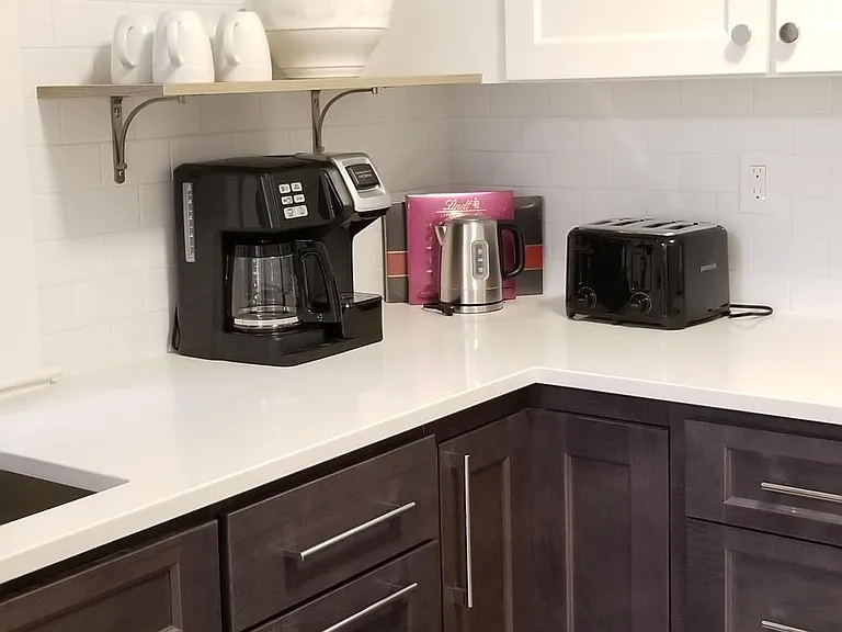 Kitchen includes built in trash/recycling door, coffee maker, electric tea kettle, toaster, blender, pots and pans, dishes for four.