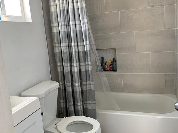 New bathtub and tile surrounds; corner unit with light and windows