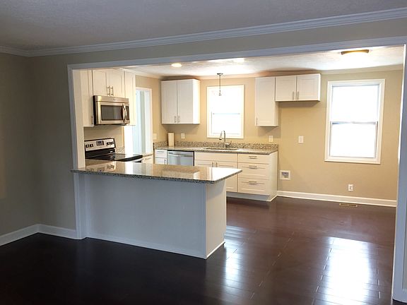 View of front door through open-concept living space into ea