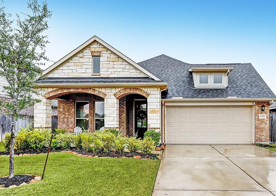 Home features highly sought after large covered front porch with stone pillars and brick arches.