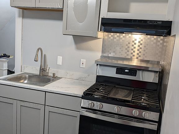 New gas stove, cabinets, sink and faucet in remodeled kitchen