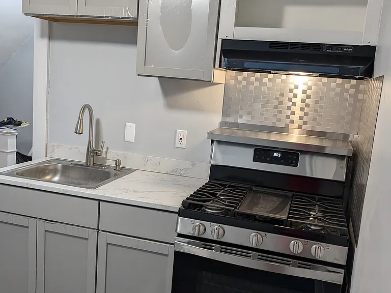 Gas stove, cabinets, sink and faucet in recently remodeled kitchen