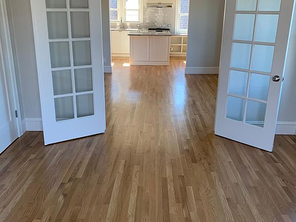 View from bedroom to kitchen - new hardwood floors throughout unit