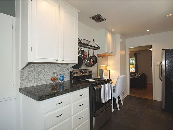 A cook's kitchen with new stainless appliances, granite counters and glass tile accents.