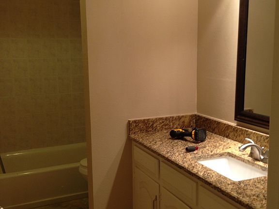 Secondary bathroom with large vanity, and tiled shower