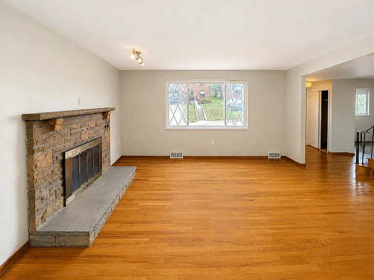 Living room w/ decorative stone fireplace.