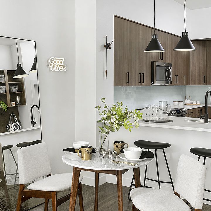 Apartment Kitchen with Stainless Steel Appliances, quartz countertop and hardwood flooring.