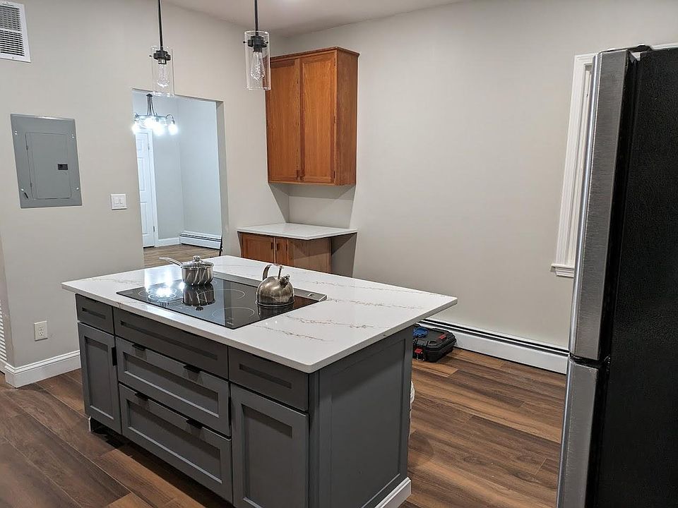 Kitchen with a new induction stove in the center island, new fridge, double oven, and dishwasher.