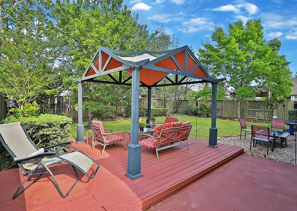 Raised deck with pergola enhance the natural beauty of this backyard!