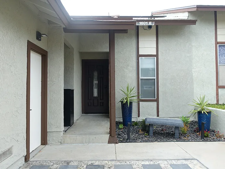 Front Entrance: Landscaped area with single car driveway parking. Side door entry to detached garage. Step-up to walkway and front door.